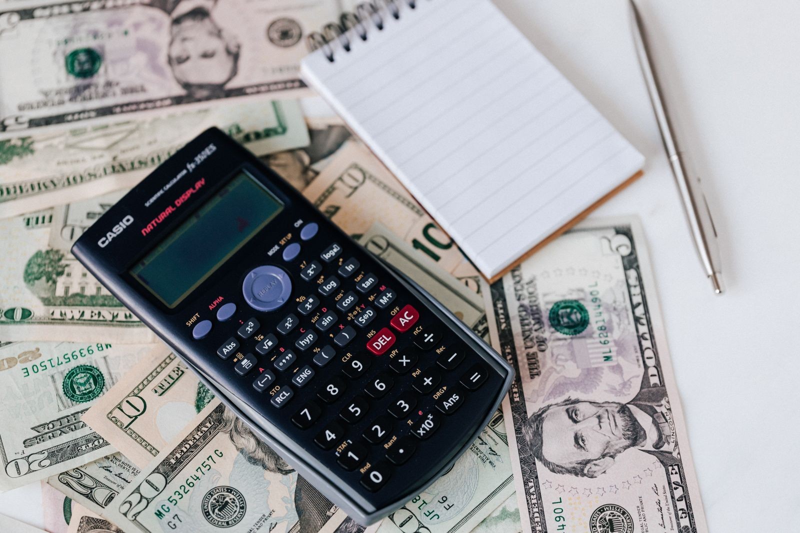 Calculadora, billetes y libreta para estimar el valor de un Funko Pop en pesos chilenos
