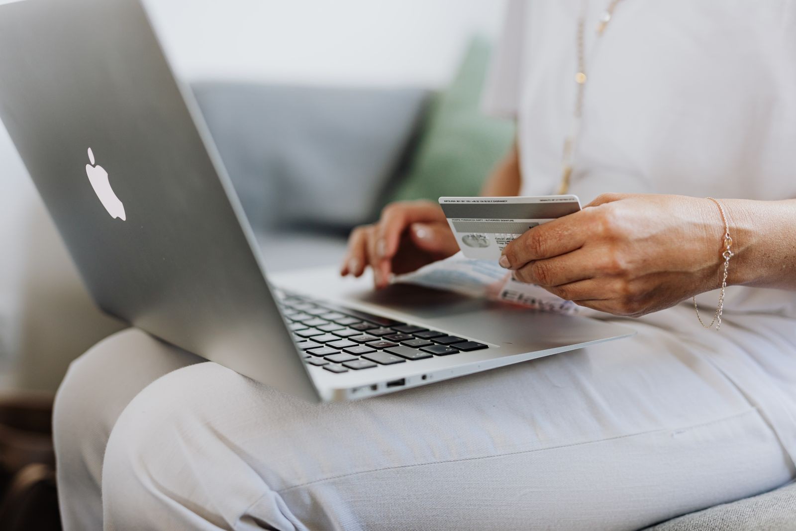 Persona cotizando precios online con laptop y tarjeta: comparar mercados de Funko Pop