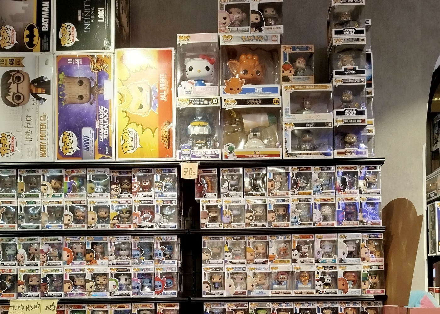 Estante real lleno de cajas Funko Pop con reflejos de luz en las ventanas PET — ejemplo de glare al fotografiar colección